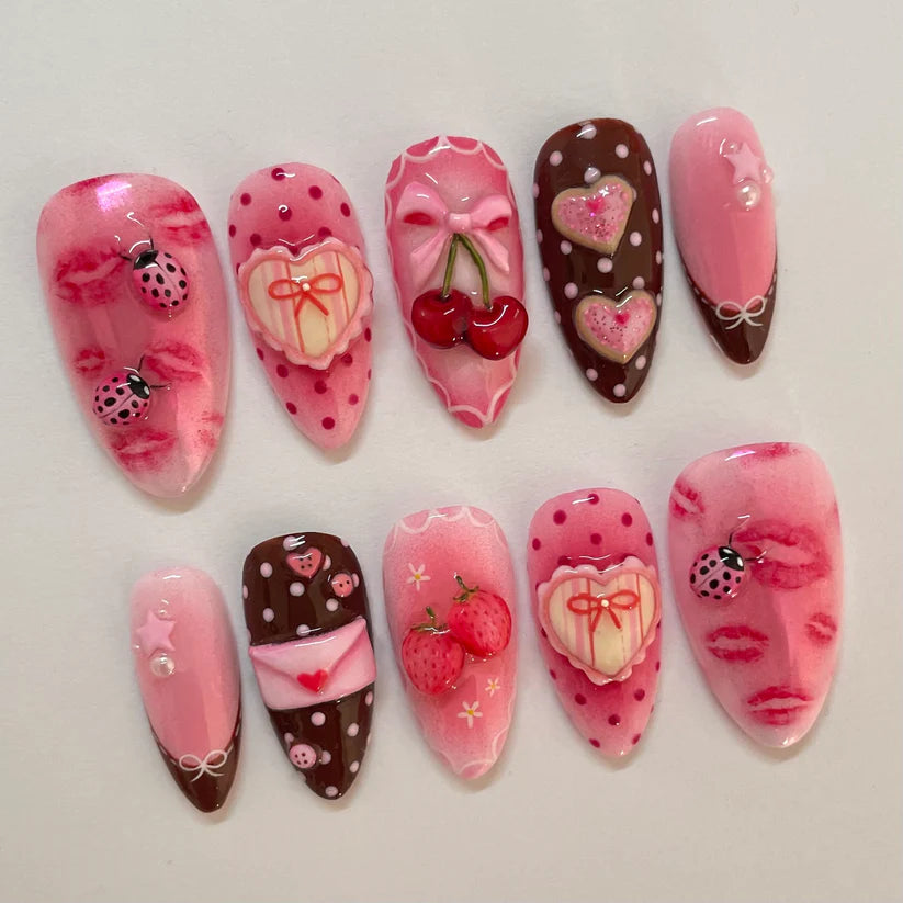 Decorative nail art with pink and brown designs on a light gray background
