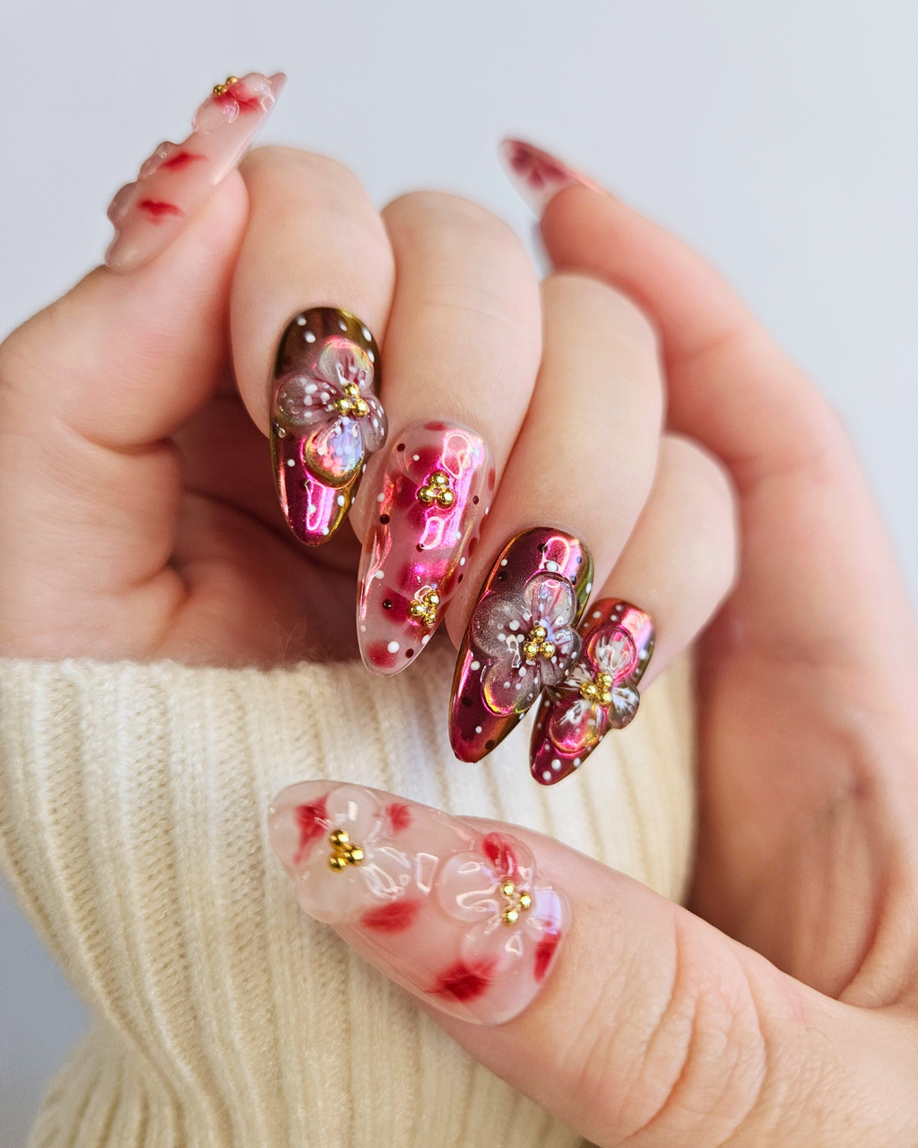 Hand with floral nail art on a light background