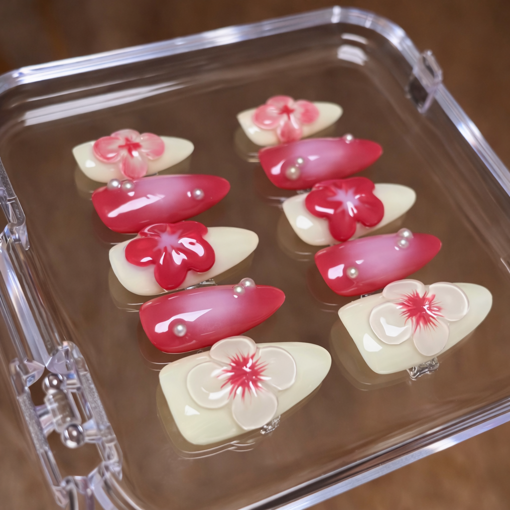 Set of artificial nails with floral designs in a clear case.
