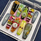 Set of colorful nail art designs in a clear case on a dark blue fabric background