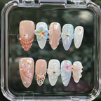 Set of decorative false nails in a clear case with a blurred green background