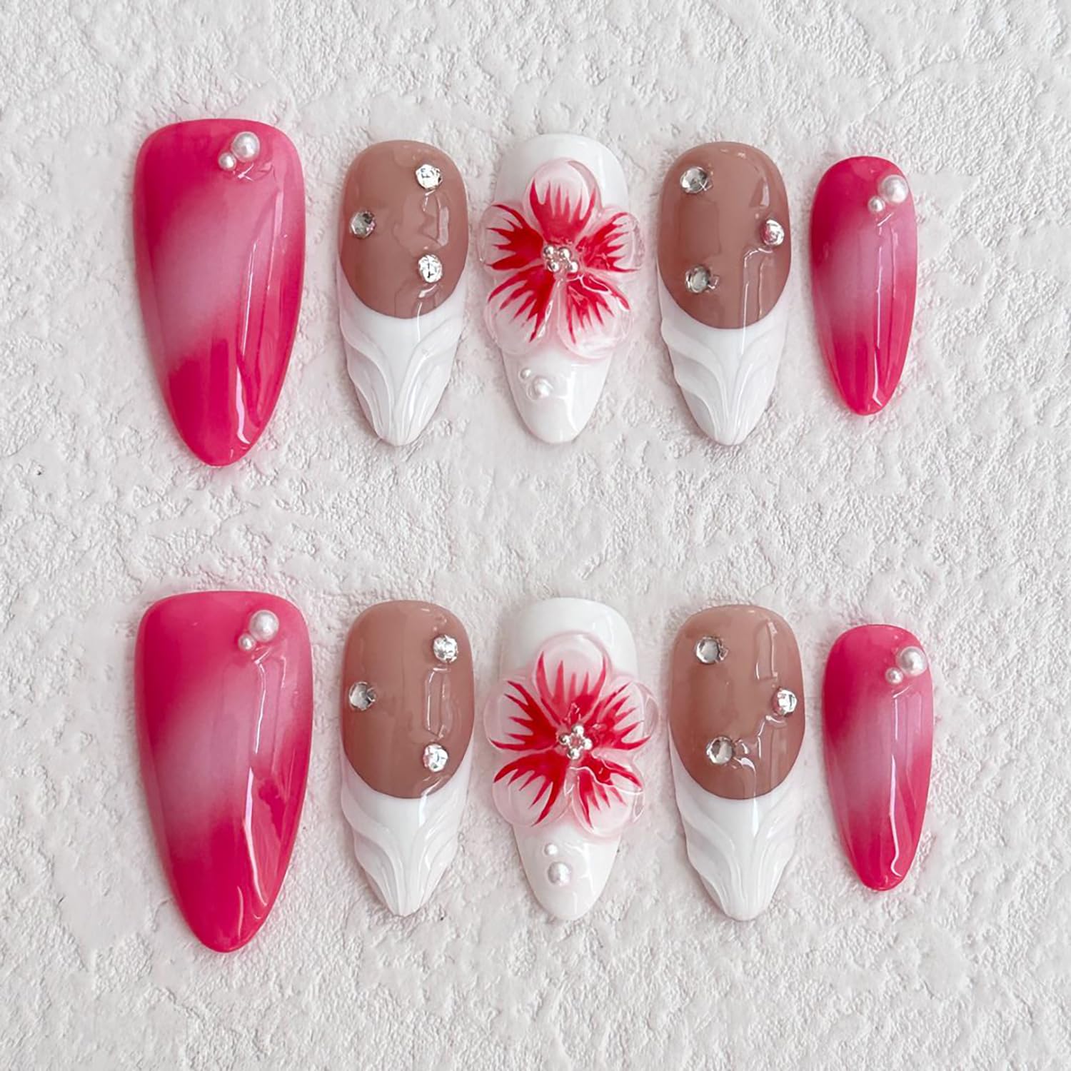 Set of decorative nails with pink, brown, and white colors on a textured white background