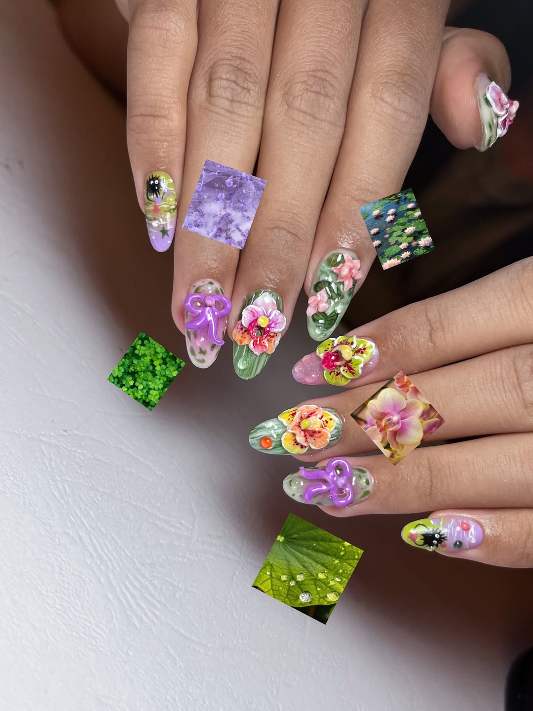 Close-up of a hand with colorful floral nail art on a white background
